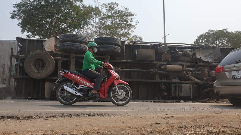 Xe tải chở đầy hàng hoá bị lật vào làn xe máy tại Hóc Môn